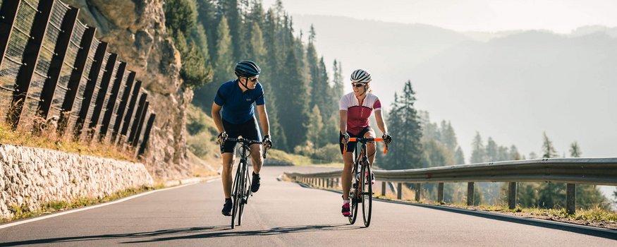 Hotel Melodia del Bosco **** © Molography Zwei Radfahrer fahren bergauf auf einer Straße in den Bergen