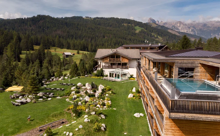 Hotel Gran Paradiso **** © Davide dal Mas Hotel mit Außenpool auf Terrasse und grüner Wiese vor Bergwald