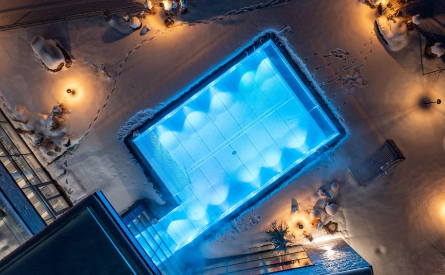 Piscina illuminata nella neve di notte vista dall'alto