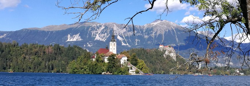 Chiesa su isola in lago con montagne sullo sfondo