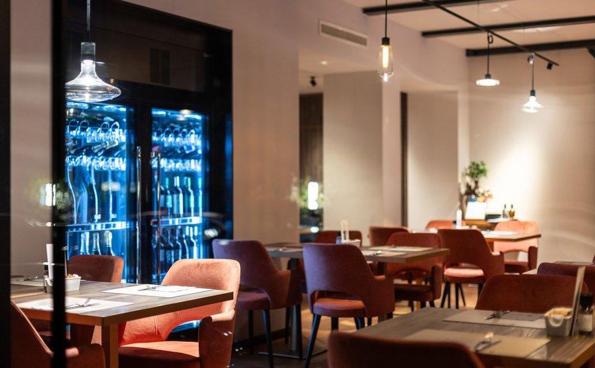 Leere moderne Restaurantbestuhlung mit Weinregal im Hintergrund