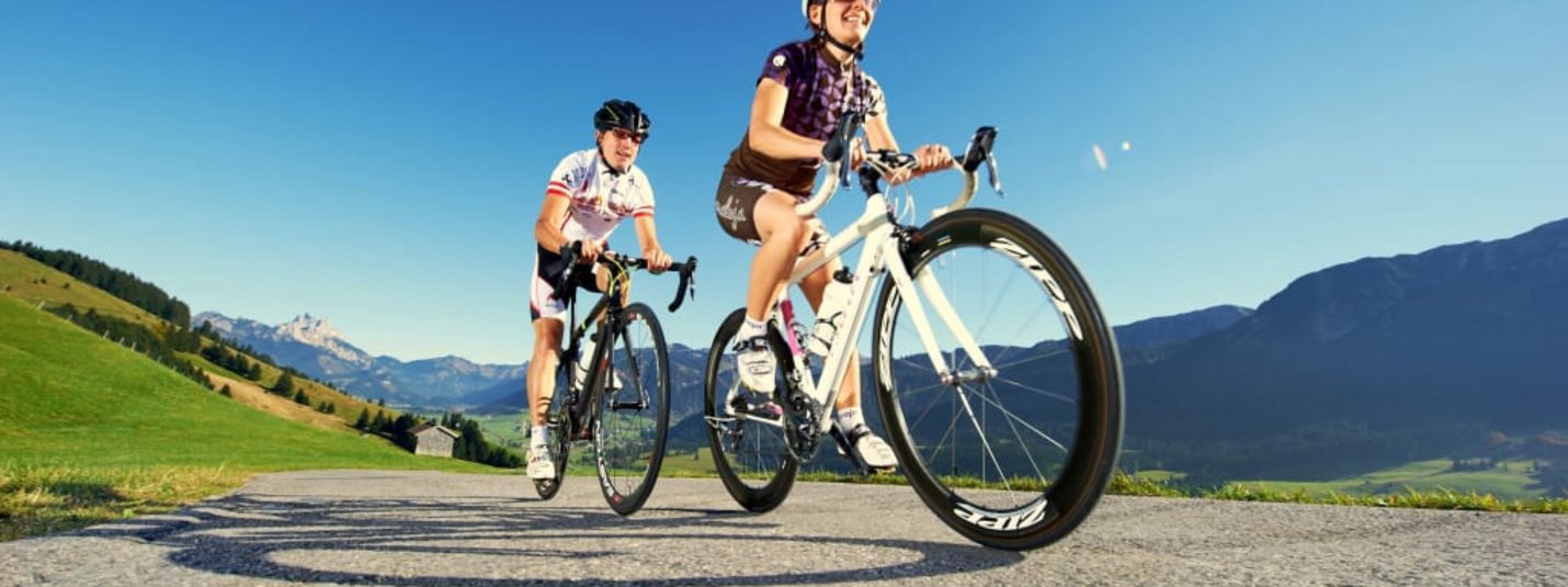 Rennradwochen Sommer - 7 Übernachtungen Zwei Radfahrer fahren auf Bergstraße bei klarem Himmel