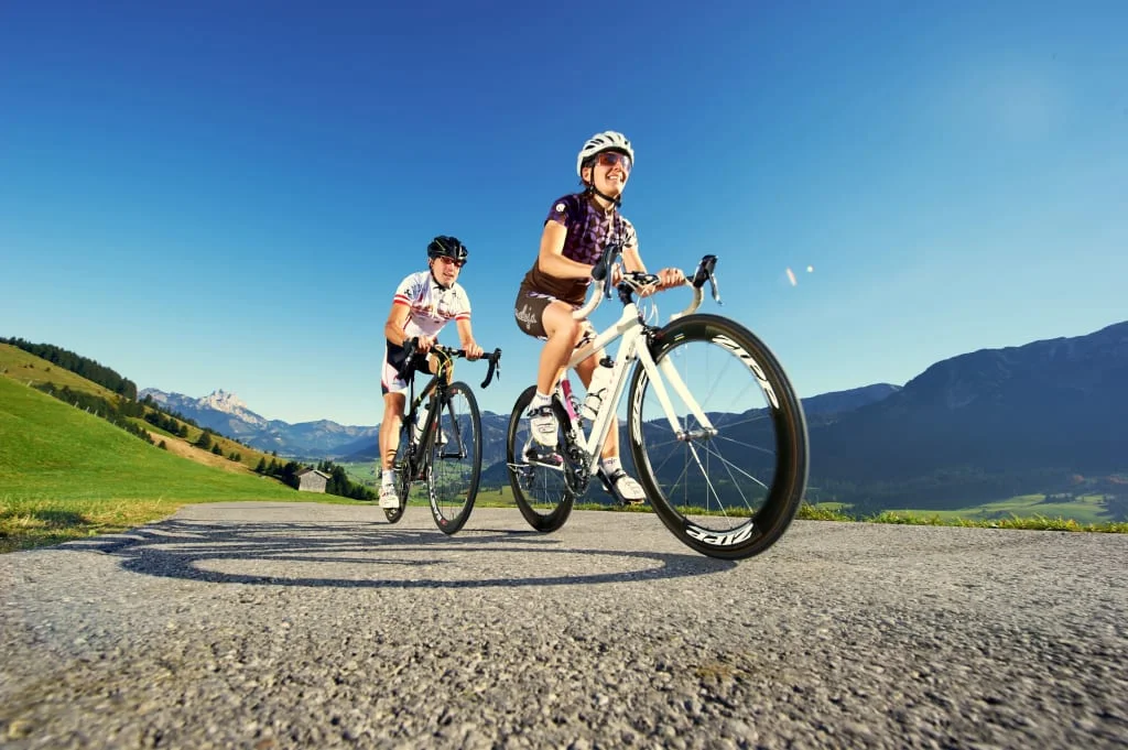 Zwei Radfahrer fahren auf Bergstraße bei klarem Himmel