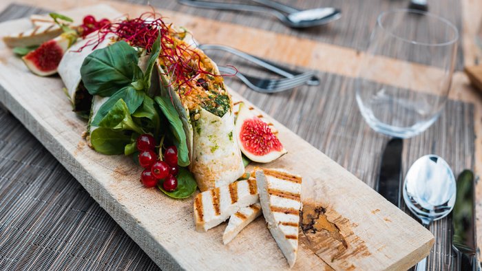 Vegane Wraps mit gegrilltem Tofu, frischen Feigen und Salat auf Holzbrett
