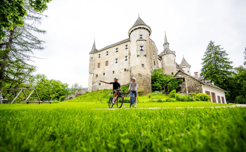 Racefietsvakantie in Midden-Karinthië © Michael Stabentheiner Twee fietsers voor een historisch kasteel in een groen landschap