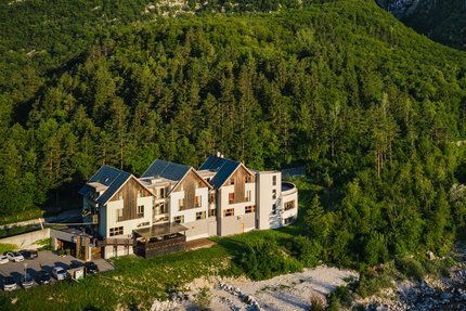 Hotel Boka © Hotel Boka Haus vor bewaldeten Bergen und Wasserfall im Tal