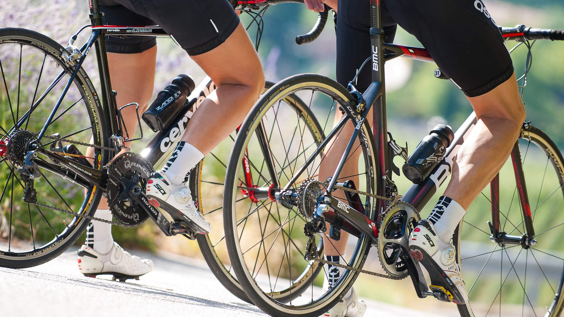 Radrennfahrer beim Bergauffahren auf Straße bei sonnigem Wetter