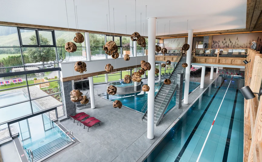 Interieur van modern overdekt zwembad met banen en houten decoraties