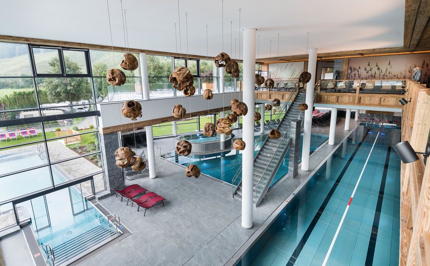 Interior of modern indoor swimming pool with lanes and wooden decorations