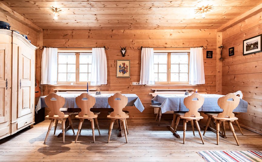 Rustikaler Essbereich mit Holzmöbeln und karierten Tischdecken in einem Holzhaus