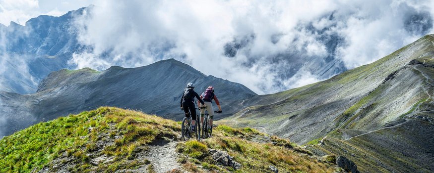 Auf Schmugglerpfaden durch Ischgl/Samnaun
© TVB Paznaun Ischgl Zwei Mountainbiker fahren auf einem Bergpfad mit Nebelschwaden