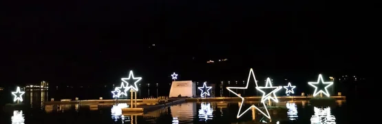 Verlichte sterren langs de waterkant weerspiegelen in het water