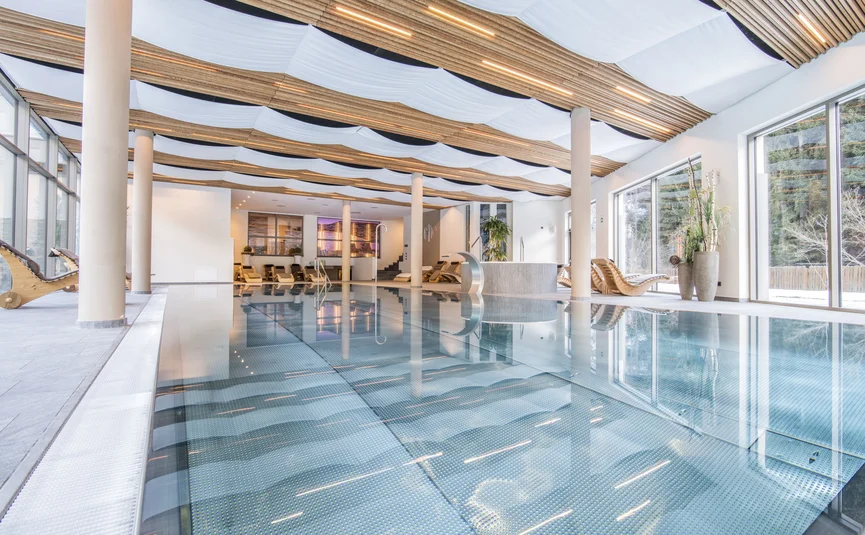 Moderner Innenpool mit Holzdecke und großen Fenstern
