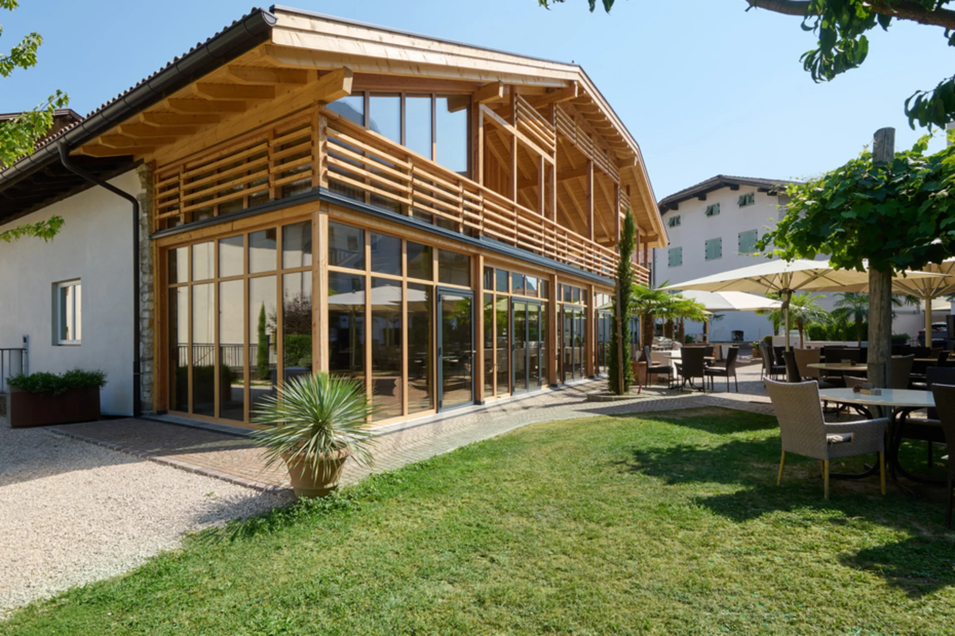 Modernes Holzgebäude mit großen Glasfronten und möblierter Gartenterrasse