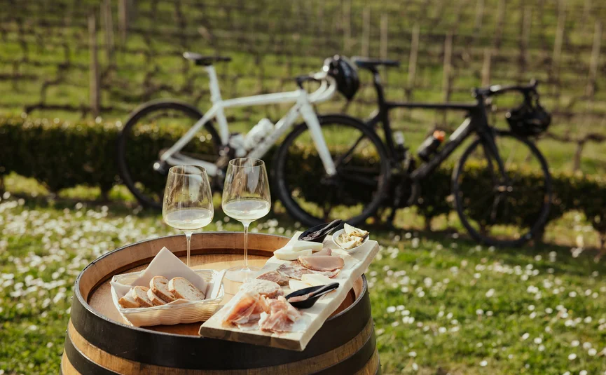 Weinprobe mit Brot, Aufschnitt und zwei Fahrrädern im Hintergrund