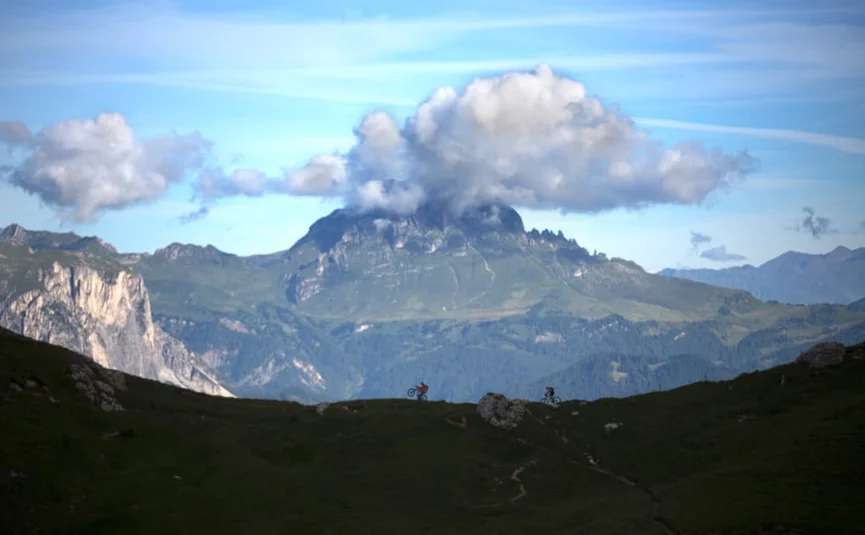 E-Bike Full Immersion Week Berglandschap met wolken boven top en fietsers op pad