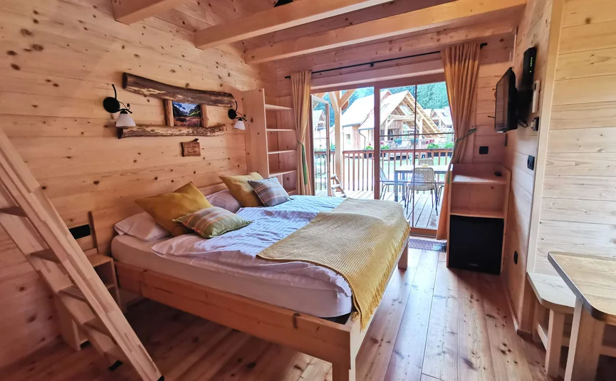 Hotel & Glamping Ribno Alpine Resort **** © Katarina Strgar Gemütliches Schlafzimmer in einer Holzhütte mit Zugang zur Terrasse