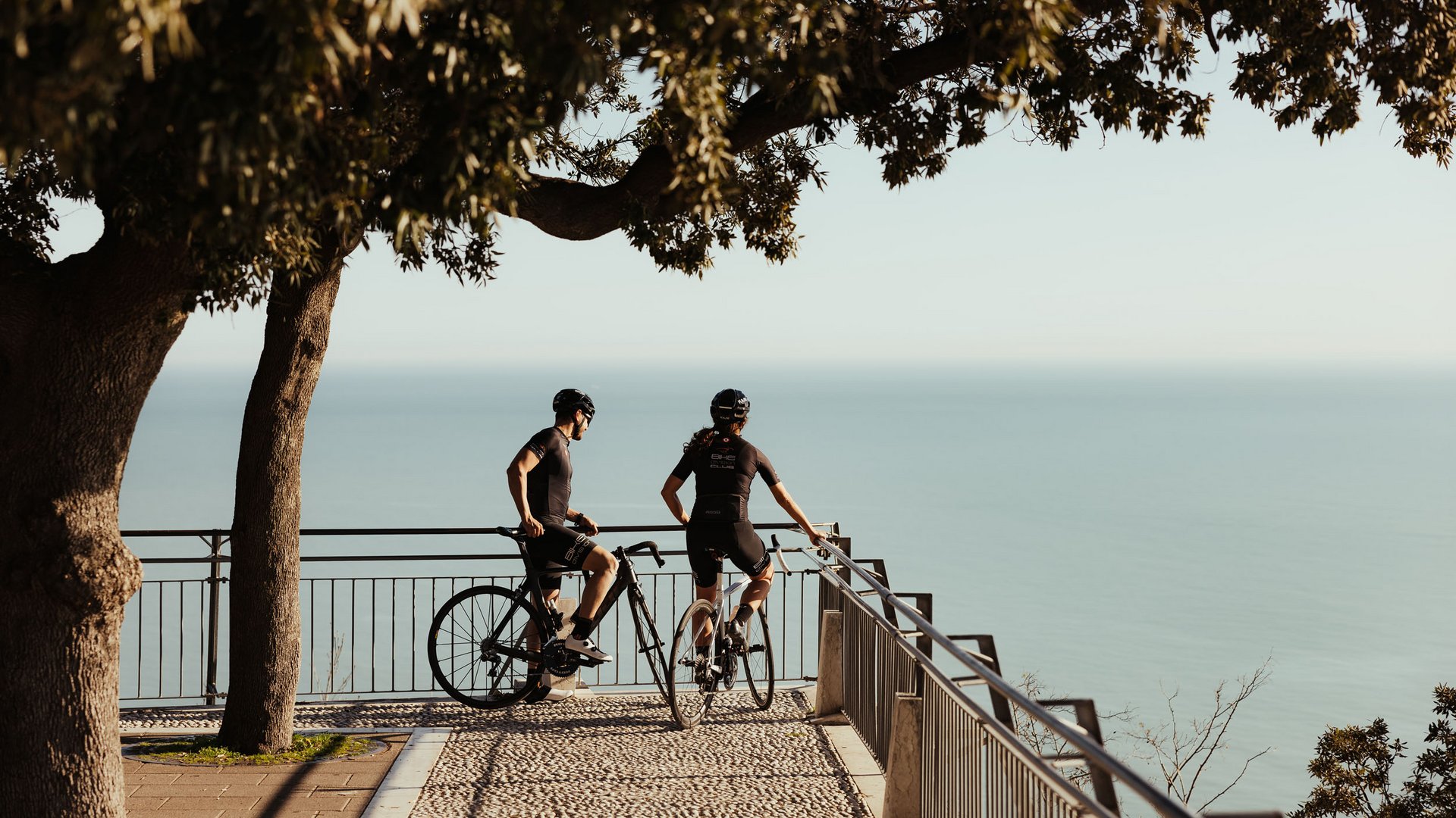 Zwei Radfahrer genießen die Aussicht von einer Aussichtsplattform am Meer