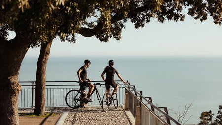 Zwei Radfahrer genießen die Aussicht von einer Aussichtsplattform am Meer