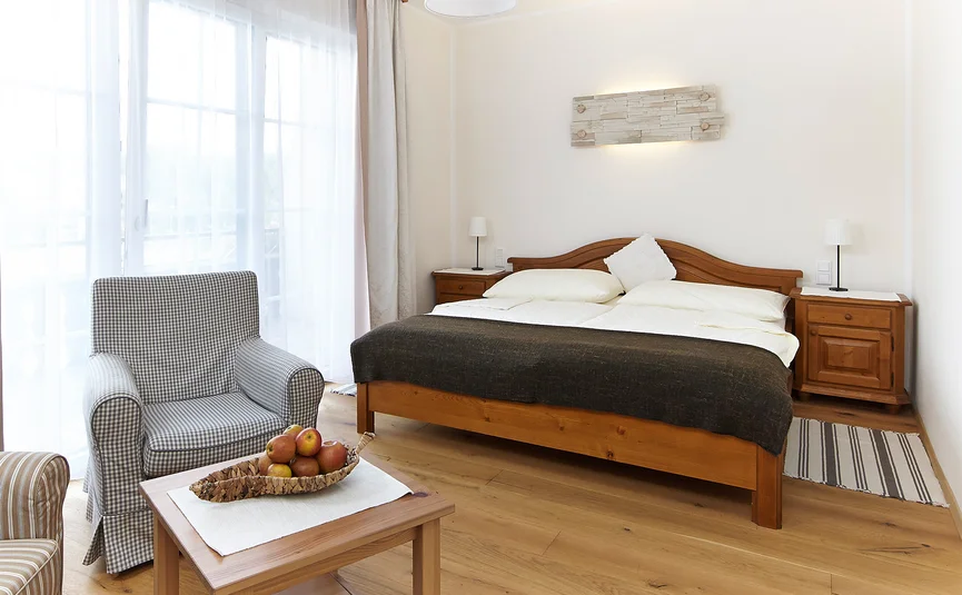 Camera da letto accogliente con mobili in legno e tende chiare