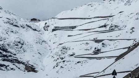 Serpentinenstraße im verschneiten Berggebiet mit Geschwindigkeitsanzeige 130