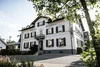 Sammelanfrage © Dimitri Dell Weißes Gasthaus Posthorn mit dunklen Fensterläden, umgeben von Bäumen