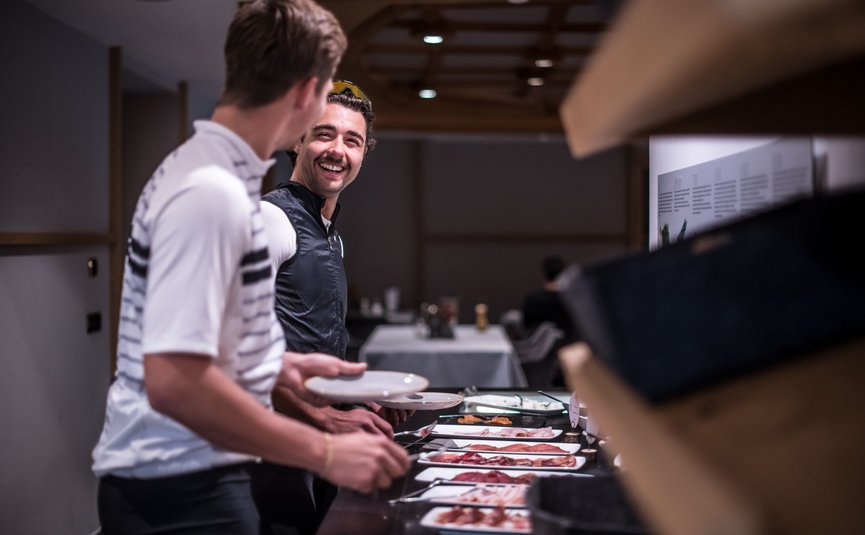 Twee mannen bij een buffet met borden en verschillende vleesplanken