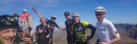 Gruppe von Radfahrern auf einem Berggipfel bei sonnigem Wetter