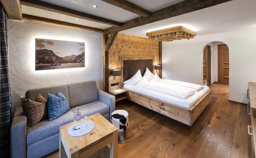 Gemütliches Hotelzimmer mit Holzmöbeln und Sofa