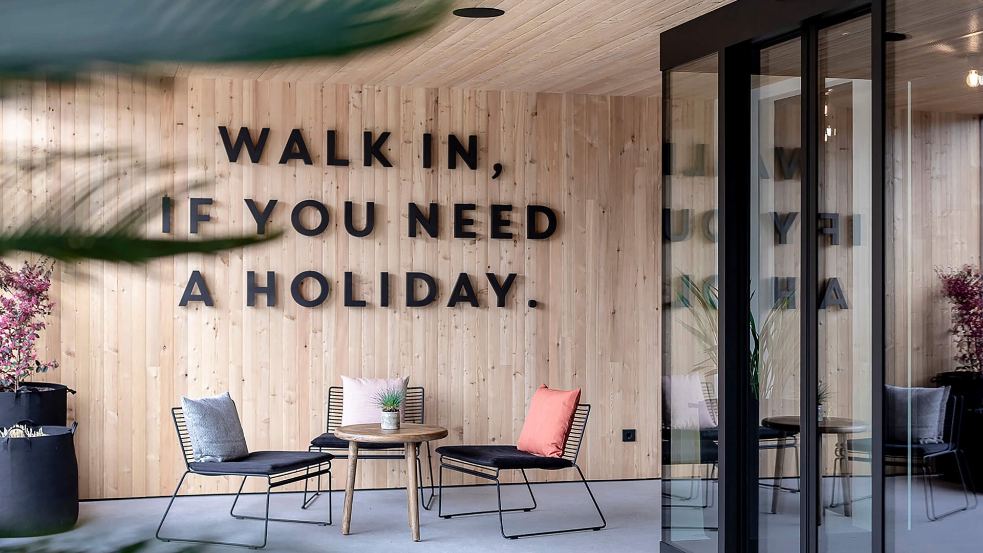 Moderne Lounge mit Holzwand und Sitzbereich mit Kissen