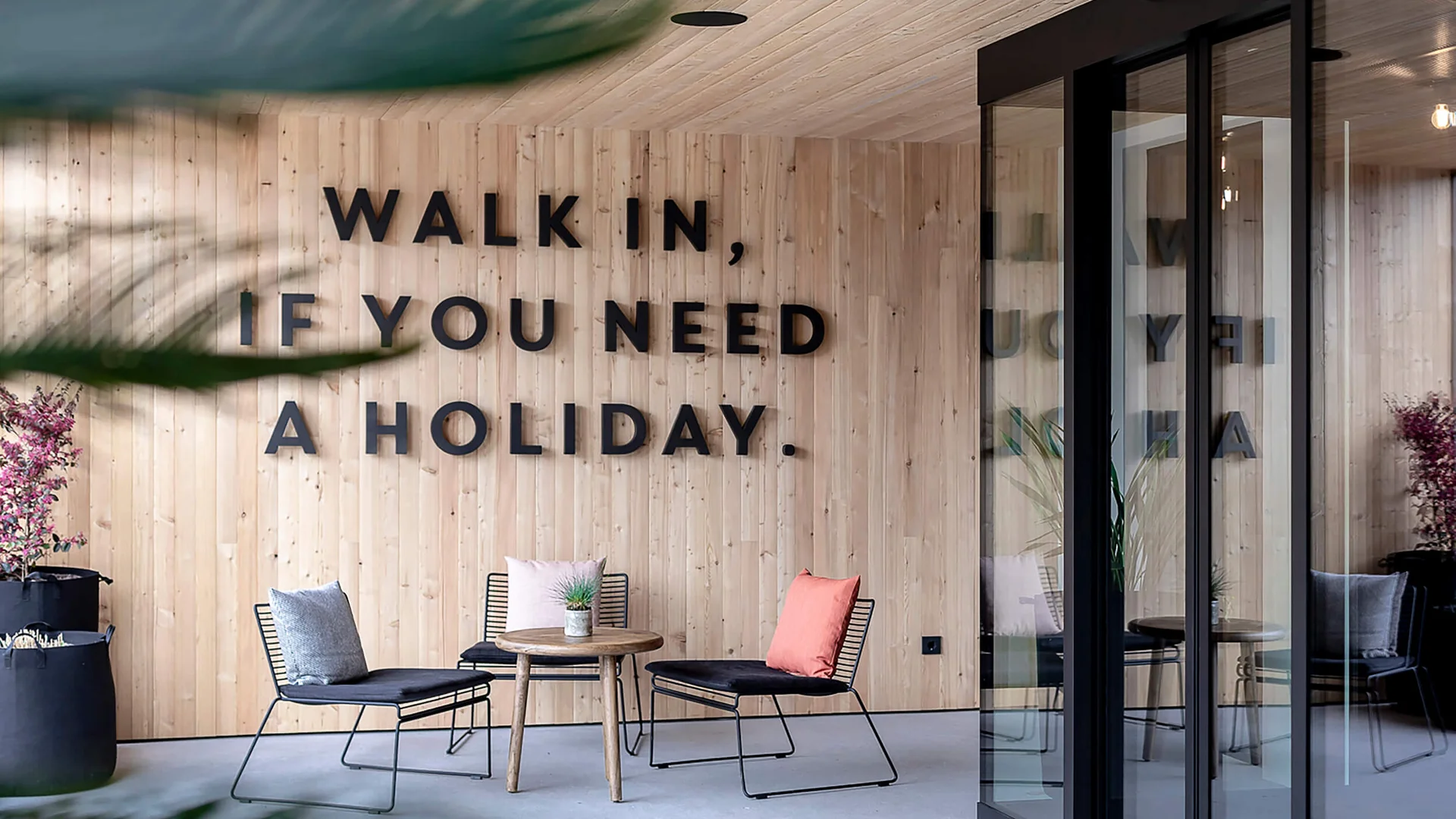 Modern lounge with wooden wall and seating area with cushions