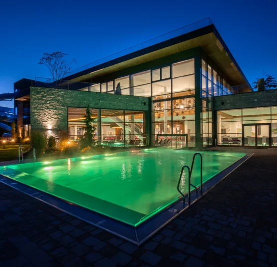 Illuminated swimming pool at a modern building at night