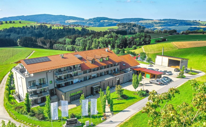 Landrefugium Obermüller ****S © Stefan J. Wolf Photography Modernes Gebäude mit rotem Dach und Autos in grüner Hügellandschaft