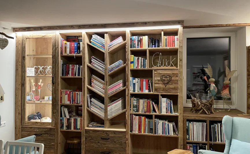 Large wooden bookshelf with books, magazines, and decor in cozy living room