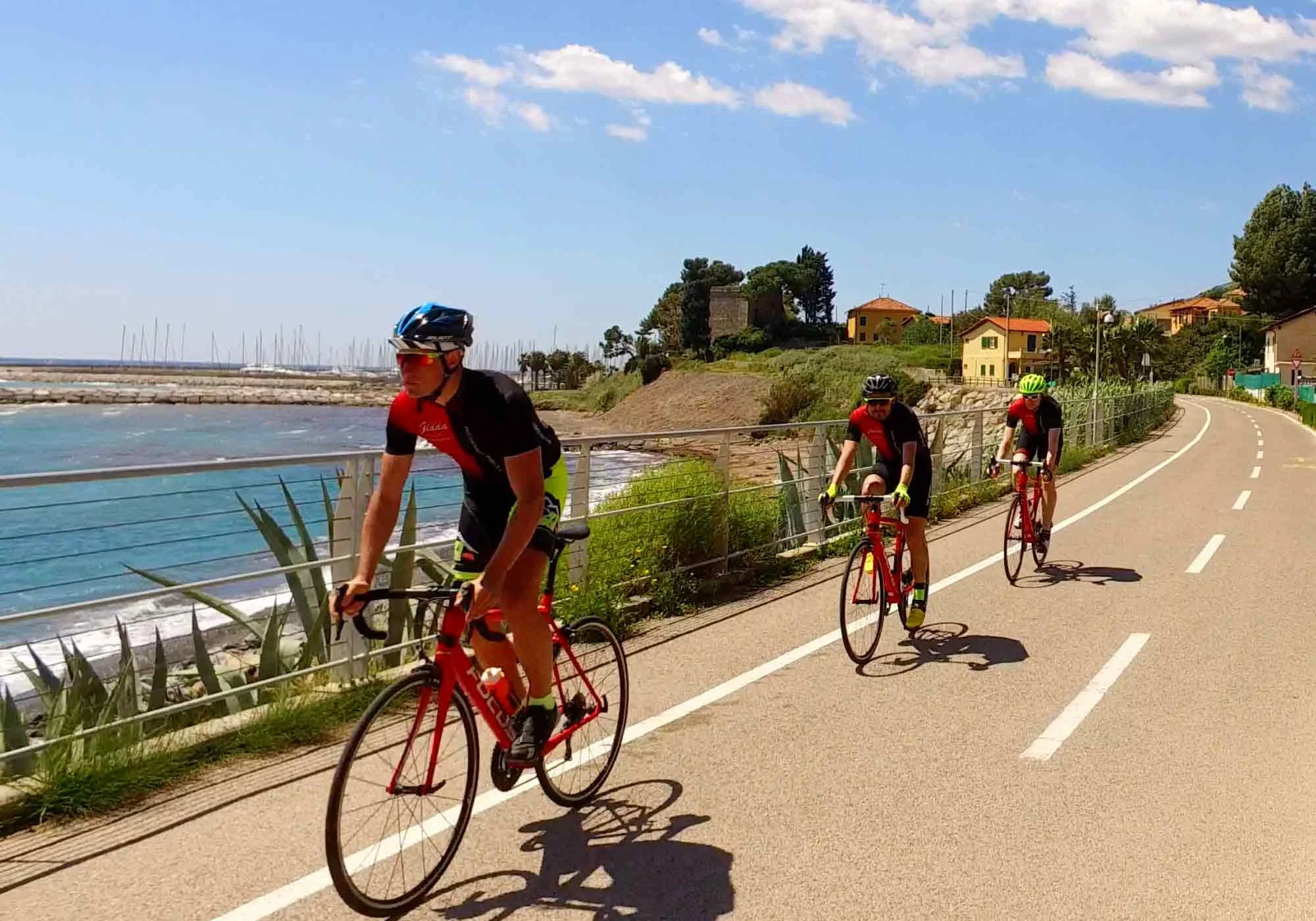 Frühling & Herbst Special: Dein perfekter Radurlaub © Villa Giada spEace & Bike Resort Drei Radfahrer fahren an der Küste auf einem sonnigen Radweg