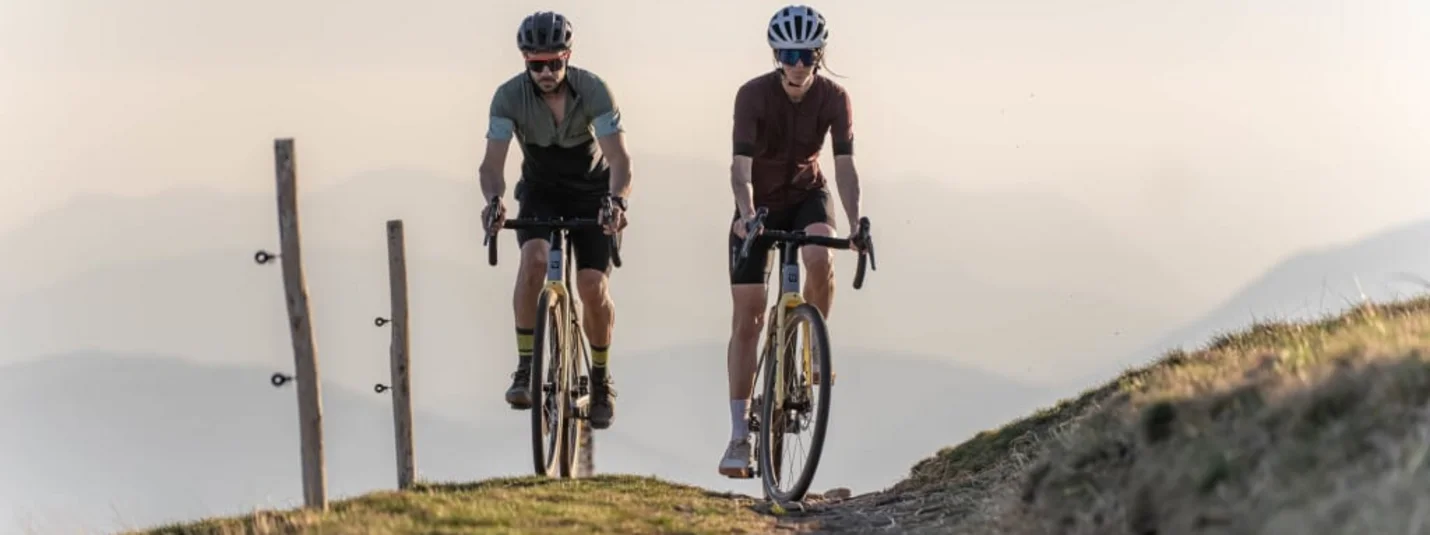 Twee fietsers op een bergpad bij zonsondergang