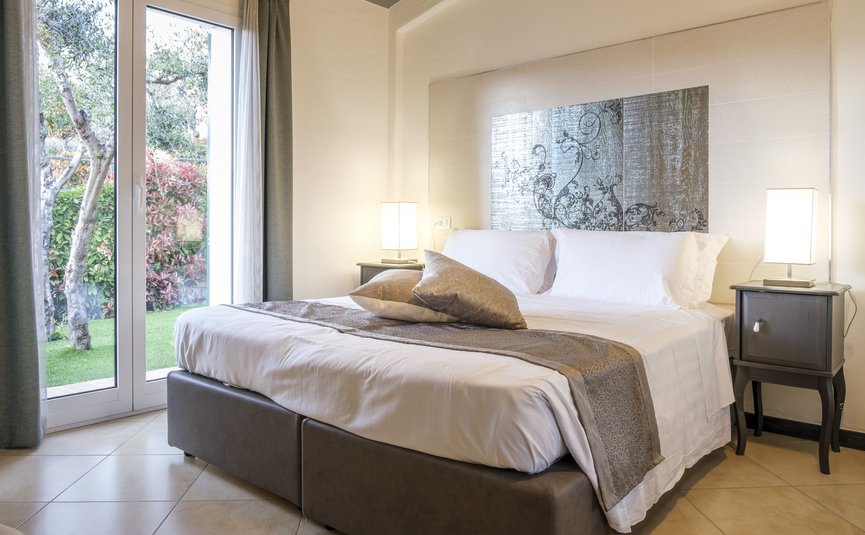 Camera da letto moderna con letto grande e vista sul giardino