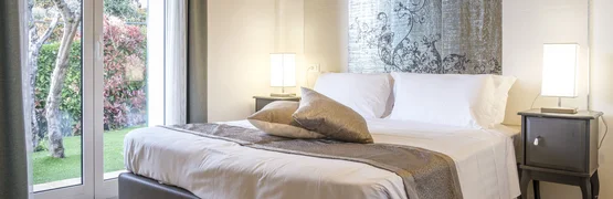 Frühling & Herbst Special: Dein perfekter Radurlaub © Villa Giada spEace & Bike Resort Modernes Schlafzimmer mit großem Bett und Blick auf Garten