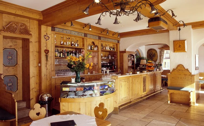 Brightly lit bar with wooden paneling and bar stools
