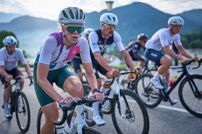Radrennsportler fahren auf einer Straße vor bergiger Kulisse