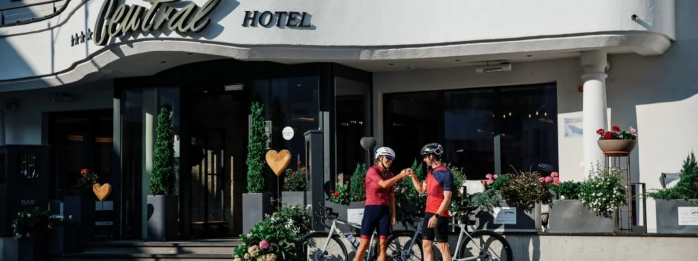 7-Tage Roadbike Package Zwei Radfahrer vor dem Central Hotel gratulieren sich mit Fistbump