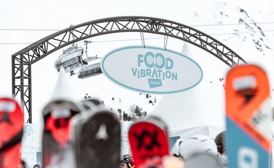 Food Vibration bord bij winterevenement met ski's en skilift op de achtergrond
