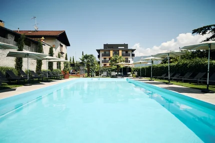 Buitenzwembad met ligstoelen en parasols bij moderne gebouwen