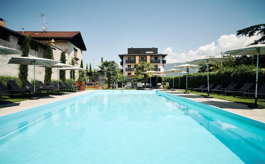 Piscina all'aperto con lettini e ombrelloni vicino a edifici moderni
