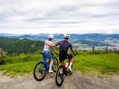Due ciclisti che ammirano il panorama dalla cima di una montagna.