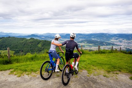 Two cyclists enjoying the view from a mountain summit.