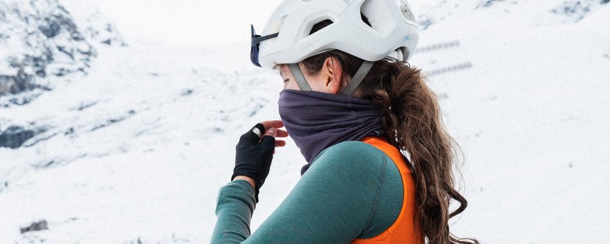 Frau mit Fahrrad und Helm in winterlicher Schneelandschaft