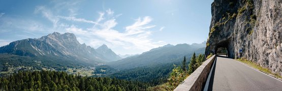 Mountain road with tunnel and valley view under clear sky