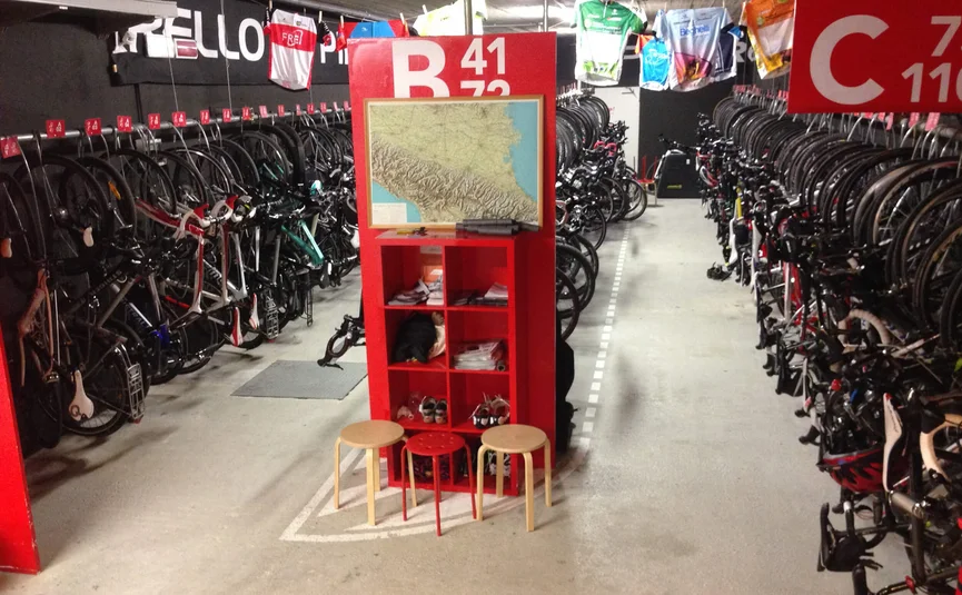 Overdekte fietsenstalling met veel racefietsen en krukjes