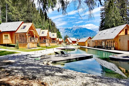 Vakantiehuisjes aan het meer met bergzicht en ligstoelen